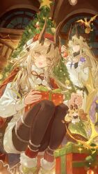  2girls arknights black_pantyhose box brown_hair cape character_charm charm_(object) christmas_tree commentary_request dragon_girl dragon_horns ergouzi_echo fur-trimmed_shoes gift gift_box gradient_hair green_eyes hair_over_one_eye hat highres horns indoors long_hair looking_at_viewer multicolored_hair multiple_girls necrass_(arknights) pantyhose pom_pom_(clothes) red_cape red_hat reed_(arknights) reed_the_flame_shadow_(arknights) reed_the_flame_shadow_(glowing_flame_in_the_night)_(arknights) santa_hat siblings sisters squatting very_long_hair 