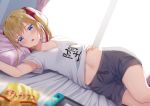  1girl alexmaster armpit_peek armpits bed_sheet black_shorts blonde_hair blue_eyes blurry bow clothes_writing collarbone commentary_request depth_of_field hair_bow long_hair looking_at_viewer lying midriff navel nintendo_switch on_back on_bed open_mouth original pillow shirt shirt_lift short_shorts short_sleeves shorts solo twintails white_shirt 