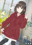  1girl 7_calpis_7 bangs black_hair black_legwear blurry blurry_background blush brown_eyes closed_mouth commentary_request day depth_of_field dutch_angle eyebrows_visible_through_hair hand_up highres hood hoodie hoodie_dress indoors long_sleeves original red_hoodie sleeves_past_wrists smile solo thigh-highs v 