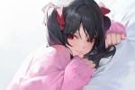  1girl bed_sheet black_hair blush bow closed_mouth dutch_angle eyebrows_visible_through_hair eyelashes eyes_visible_through_hair hair_between_eyes hair_bow lips love_live! love_live!_school_idol_project lying medium_hair mossi on_bed on_stomach pink_sweater red_bow red_eyes sideways_glance simple_background sleeves_past_wrists smile solo sweater twintails upper_body white_background yazawa_nico 