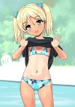  1girl beach bikini black_shirt blonde_hair blue_bikini blue_eyes commentary_request contrapposto cowboy_shot day flat_chest head_tilt highres jiji looking_at_viewer navel one-piece_tan original outdoors shirt shirt_lift short_hair smile solo standing swimsuit t-shirt tan tanline twintails 