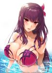  1girl alternate_costume bangs bare_shoulders bikini blush breasts bursting_breasts fate/grand_order fate_(series) flower hair_between_eyes hair_flower hair_intakes hair_ornament hibiscus highres kojima_saya large_breasts long_hair looking_at_viewer ocean partially_submerged pink_bikini purple_bikini purple_hair red_eyes scathach_(fate)_(all) scathach_(swimsuit_assassin)_(fate) skindentation smile solo swimsuit water 