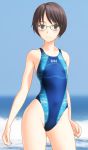  1girl black_eyes black_hair blue_swimsuit blurry breasts clothes_writing competition_swimsuit cowboy_shot depth_of_field glasses highleg highleg_swimsuit highres horizon looking_at_viewer ocean one-piece_swimsuit original short_hair small_breasts solo standing swimsuit takafumi waves 