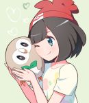  1girl bangs beanie bird black_hair blue_eyes blush cheek_press closed_mouth commentary eyelashes gen_7_pokemon green_background hands_up hat heart holding holding_pokemon kurochiroko one_eye_closed owl pokemon pokemon_(creature) pokemon_(game) pokemon_sm red_headwear rowlet selene_(pokemon) shirt short_hair short_sleeves smile t-shirt upper_body 