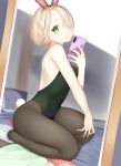  1girl absurdres animal_ears bare_arms bare_shoulders black_legwear black_leotard blonde_hair blush bunny_tail bunnysuit cellphone closed_mouth dutch_angle fake_animal_ears forehead full_body green_eyes hair_over_one_eye highres leotard looking_at_viewer mirror nametarou_(meron) original pantyhose phone rabbit_ears raised_eyebrows reaching_out reflection seiza self_shot short_hair sitting smartphone smile solo strapless strapless_leotard tail 