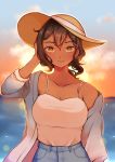  1girl brown_hair butterfly_soup dark_skin denim diya_(butterfly_soup) hand_in_hair hat highres jeans looking_at_viewer ocean outdoors pants ponytail sky smile solo strawberiisoda sun_hat sunset tank_top yellow_eyes 