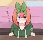  1girl bangs blue_eyes blush breast_rest breasts closed_mouth collarbone commentary_request drawstring eyebrows_behind_hair go-toubun_no_hanayome green_hoodie green_ribbon hair_between_eyes hair_ribbon hands_up hood hood_down hoodie kujou_karasuma long_sleeves looking_at_viewer medium_breasts nakano_yotsuba nose_blush orange_hair ribbon signature solo sweat table translation_request wavy_mouth 