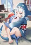  1girl bangs bare_legs barefoot bed bedroom biting bloop_(gawr_gura) blue_eyes blue_hair blue_hoodie blunt_bangs blurry blurry_background bookshelf computer curtains day flipped_hair gawr_gura hat hat_writing hololive hololive_english hood hug indian_style indoors knees_up long_hair long_sleeves looking_at_viewer monitor multicolored_hair on_bed one_eye_closed pillow pocket red_headwear room shadow shark_hood shark_tail sharp_teeth sitting sitting_on_bed sleeves_past_wrists smile streaked_hair tail tears teeth tienao virtual_youtuber white_hair window 