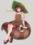 1girl animal_ears bell black_footwear brown_eyes brown_hair brown_shirt brown_skirt clog_sandals full_body futatsuiwa_mamizou green_headwear grey_background hat highres holding jingle_bell kiseru leaf leaf_on_head looking_at_viewer miniskirt paburisiyasu pipe raccoon_ears raccoon_girl shirt short_hair short_sleeves simple_background sitting sitting_on_tail skirt smile solo tail touhou