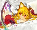  1girl animal_ears beads bed blonde_hair blush bow cat_ears closed_mouth commentary_request crossed_arms crystal dress dutch_angle eyebrows_visible_through_hair flandre_scarlet fuupu hair_between_eyes hair_bow hat head_rest highres kemonomimi_mode long_hair looking_to_the_side lying mob_cap on_stomach puffy_short_sleeves puffy_sleeves red_bow red_dress red_eyes short_sleeves smile solo top-down_bottom-up touhou wings 