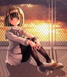  1girl black_legwear bow brown_eyes brown_hair fence full_body grey_bow grey_footwear grey_skirt kawanobe leg_hug looking_at_viewer original outdoors pantyhose school_uniform serafuku shadow short_hair skirt sunset 