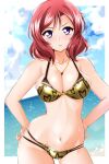  1girl bikini blue_sky blush breasts closed_mouth clouds commentary_request day frown gold_bikini hands_on_hips heart heart_print highres jewelry kirisaki_reina large_breasts looking_at_viewer love_live! love_live!_school_idol_project navel necklace nishikino_maki ocean outdoors redhead short_hair sky solo swimsuit violet_eyes wet 