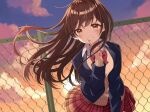  1girl brown_eyes brown_hair cardigan chain-link_fence fence finger_to_mouth hair_blowing highres long_hair looking_at_viewer original outdoors plaid plaid_skirt school_uniform shushing skirt smile solo sunset uramakaron wind 