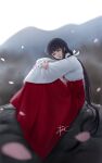  1girl absurdres black_hair blurry blurry_background brown_eyes hakama highres inuyasha japanese_clothes jewelry kikyou_(inuyasha) lips long_hair looking_at_viewer miko mountainous_horizon necklace outdoors petals ponytail red_hakama signature sitting solo zyl 