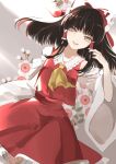  1girl ascot bangs black_hair blunt_bangs bow brown_eyes brown_hair collared_shirt commentary detached_sleeves dutch_angle floating_hair floral_background flower frilled_bow frilled_shirt_collar frilled_skirt frills grey_background hair_bow hair_tousle hair_tubes hakurei_reimu hand_in_hair hand_up highres joniko1110 long_hair looking_at_viewer open_mouth plum_blossoms red_bow red_ribbon red_shirt red_skirt ribbon ribbon-trimmed_collar ribbon-trimmed_sleeves ribbon_trim shirt sidelocks skirt skirt_set solo touhou upper_teeth white_flower wide_sleeves yellow_neckwear 