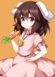  1girl animal_ears bangs black_hair bunny_tail carrot carrot_necklace closed_mouth dress eating eyebrows_visible_through_hair floppy_ears food food_on_face hair_between_eyes highres holding holding_food inaba_tewi looking_at_viewer medium_hair orange_background pink_dress rabbit_ears ruu_(tksymkw) short_sleeves simple_background smile solo standing tail touhou white_tail 