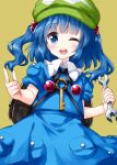  1girl backpack bag bangs black_bag blue_dress blue_eyes blue_hair blunt_bangs cowboy_shot dress eyebrows_visible_through_hair flat_cap green_headwear hair_bobbles hair_ornament hat highres holding holding_wrench kawashiro_nitori key looking_at_viewer medium_hair one_eye_closed open_mouth pocket pointing ruu_(tksymkw) simple_background smile solo standing teeth touhou two_side_up wrench yellow_background 