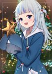  1girl :d bangs blue_eyes blue_hair blue_hoodie blush christmas christmas_ornaments christmas_tree commentary drawstring eyebrows_behind_hair gawr_gura grey_hair hair_ornament hands_up highres holding hololive hololive_english hood hood_down hoodie long_hair multicolored_hair open_mouth sharp_teeth smile solo streaked_hair teeth two_side_up uneg virtual_youtuber 