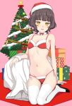  1girl alternate_costume bangs bikini blunt_bangs blush box breasts brown_eyes brown_hair choker christmas christmas_ornaments christmas_tree eyebrows_visible_through_hair fur_trim gift gift_box hat high_heels highres kantai_collection kishinami_(kantai_collection) kumadano looking_at_viewer navel open_mouth red_bikini sack santa_bikini santa_costume santa_hat short_hair side-tie_bikini small_breasts smile solo swimsuit symbol_commentary thigh-highs wavy_hair white_legwear 