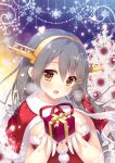  1girl :d box brown_eyes capelet christmas christmas_tree english_commentary eyebrows_visible_through_hair fur-trimmed_capelet fur_trim gift gift_box grey_hair hair_ornament hairclip haruna_(kantai_collection) headgear highres holding holding_box kantai_collection long_hair open_mouth red_capelet remodel_(kantai_collection) santa_costume shigunyan smile solo upper_body 