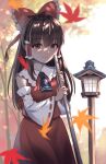  1girl arms_up autumn_leaves bangs black_eyes black_hair blue_neckwear blurry blurry_background blurry_foreground bokeh bow broom cowboy_shot cravat dappled_sunlight day depth_of_field detached_sleeves douji eyebrows_visible_through_hair falling_leaves hair_bow hair_tubes hakurei_reimu highres holding holding_broom lantern leaf light_blush long_hair looking_at_viewer maple_leaf outdoors red_skirt red_vest ribbon-trimmed_sleeves ribbon_trim sidelocks skirt smile solo standing sunlight touhou tree vest 