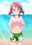  1girl asymmetrical_bangs bangs bare_legs beach belly blush brown_hair collarbone commentary_request cowboy_shot day floral_print flower green_shorts hair_flower hair_ornament hairpin hanadera_nodoka healin&#039;_good_precure highres light_rays navel nose_blush ocean outdoors pink_eyes pink_shirt precure rin_takanashi_glacies sand shiny shiny_skin shirt shirt_lift short_hair short_twintails shorts smile solo stomach toned twintails 