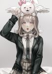  1girl arm_up bangs black_jacket black_shirt breasts brown_hair collared_shirt dangan_ronpa_(series) dangan_ronpa_2:_goodbye_despair dress_shirt ear_bow flipped_hair frilled_skirt frills grey_background hair_ornament hairclip highres hood jacket looking_up medium_breasts medium_hair muuyiie nanami_chiaki on_head on_person open_clothes open_jacket pink_eyes pink_skirt shiny shiny_hair shirt shirt_tucked_in sitting skirt symbol_commentary two-tone_shirt usami_(dangan_ronpa) wings 