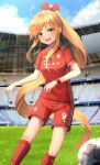  1girl :d ball blonde_hair blue_sky blush bow clouds fc_bayern_munchen field green_eyes hair_bow highres kerno long_hair looking_at_viewer open_mouth original outdoors ponytail red_bow red_legwear red_shirt red_shorts shirt short_sleeves shorts sky smile soccer_ball soccer_uniform socks solo sportswear stadium standing 