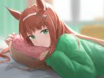  1girl bangs blurry blurry_background blush brown_hair character_request closed_mouth depth_of_field doughnut_pillow eyebrows_visible_through_hair from_side green_eyes green_sweater hairband highres long_hair long_sleeves looking_at_viewer looking_to_the_side lying on_stomach pillow sleeves_past_wrists smile solo sweater tadano_tarako umamusume upper_body white_hairband 