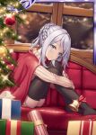  1girl akkijin ass bell blue_eyes box braid cape christmas christmas_tree couch gift gift_box grey_hair indoors lonely looking_at_viewer no_shoes official_art red_cape sad shinkai_no_valkyrie sitting snowing sweater thigh-highs window 