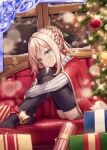  1girl akkijin ass bell blonde_hair box braid cape christmas christmas_tree couch gift gift_box green_eyes hair_ornament indoors lonely looking_at_viewer no_shoes official_art red_cape sad shinkai_no_valkyrie sitting snowing sweater thigh-highs window 
