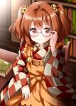  1girl apron bangs bell blush book chair checkered checkered_kimono closed_mouth clothes_writing cowboy_shot glasses hair_bell hair_between_eyes hair_ornament hand_up highres holding holding_eyewear indoors japanese_clothes kimono library long_sleeves looking_at_viewer medium_hair motoori_kosuzu red_eyes ruu_(tksymkw) sitting solo table touhou twintails wooden_chair 