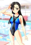  1girl absurdres asymmetrical_bangs bangs black_hair breasts brown_eyes clothes_writing collarbone commentary_request competition_swimsuit cowboy_shot girls_und_panzer highres indoors long_hair looking_at_viewer multicolored multicolored_clothes multicolored_swimsuit nishi_kinuyo one-piece_swimsuit pool salute small_breasts solo straight_hair swimsuit takafumi 