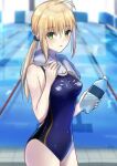  1girl :o ahoge artoria_pendragon_(all) blonde_hair bottle fate_(series) green_eyes hair_between_eyes highres indoors long_hair looking_to_the_side one-piece_swimsuit pale_skin pool saber sidelocks sii_artatm solo swimsuit towel water_bottle wet 