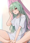  1girl anchovy_(girls_und_panzer) bangs commentary girls_und_panzer green_hair half-closed_eye hand_in_hair highres indian_style kakimoto_nao long_hair one_eye_closed red_eyes shirt short_sleeves sitting sleepwear sleepy solo t-shirt white_shirt 