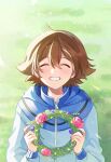  1boy bangs blue_jacket blush brown_hair closed_eyes day flower grass grin hair_between_eyes hands_up highres hilbert_(pokemon) holding hood hooded_jacket jacket long_sleeves male_focus outdoors p_(flavorppp) pokemon pokemon_(game) pokemon_bw short_hair smile solo symbol_commentary wreath zipper_pull_tab 