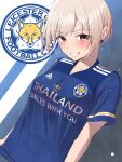  1girl adidas bangs blonde_hair blue_background blue_shirt blush breasts brown_eyes clothes_writing collarbone commentary_request earrings eyebrows_visible_through_hair grin highres idolmaster idolmaster_cinderella_girls jewelry k-chitsu leicester_city_fc logo looking_at_viewer medium_breasts parted_bangs premier_league shiomi_shuuko shirt short_hair short_sleeves sidelocks smile soccer_uniform solo sportswear standing teeth trait_connection two-tone_background upper_body white_background 
