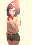  1girl absurdres beanie blush brown_hair closed_mouth collarbone commentary_request eyelashes floral_print flower green_shorts hand_up hat highres holding holding_flower medium_hair pokemon pokemon_(game) pokemon_sm red_flower red_headwear selene_(pokemon) shirt short_shorts short_sleeves shorts solo t-shirt tied_shirt yellow_shirt yoshiyoshiwa 