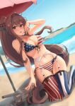  1girl alternate_costume american_flag_bikini ass_visible_through_thighs bangs bare_arms bare_shoulders beach beach_umbrella bikini blush breasts brown_eyes brown_hair cherry_blossoms commentary day flag_print flower front-tie_bikini front-tie_top garter_belt groin hair_flower hair_intakes hair_ornament headgear highres k_jie kantai_collection kneeling large_breasts long_hair looking_at_viewer navel ocean open_mouth outdoors parasol ponytail red_umbrella side-tie_bikini smile solo striped swimsuit symbol_commentary thigh-highs turret umbrella very_long_hair water yamato_(kancolle) 