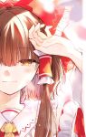  1girl arm_up bangs blunt_bangs blurry blurry_foreground blush bow brown_hair detached_sleeves eyebrows_visible_through_hair frilled_bow frilled_hair_tubes frilled_shirt_collar frills hair_bow hair_tubes hakurei_reimu half-closed_eye hand_on_own_head highres light_smile long_hair out_of_frame poprication portrait red_bow red_ribbon ribbon solo symbol_commentary tears touhou yellow_eyes yellow_neckwear 