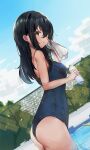  1girl black_hair blue_swimsuit bottle cowboy_shot day dutch_angle fence from_side highres holding holding_bottle kure_(kure_ng) long_hair looking_at_viewer one-piece_swimsuit outdoors pool princess_connect! school_swimsuit shiori_(princess_connect!) solo swimsuit towel water_bottle wet wiping_face yellow_eyes 