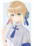  1girl ahoge artoria_pendragon_(fate) blonde_hair chinese_clothes fate/grand_order fate/stay_night fate_(series) food green_eyes hair_between_eyes holding holding_food looking_at_viewer medium_hair saber sakurasakimasu4 shirt short_sleeves sidelocks smile solo two-tone_background upper_body white_shirt 