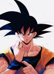  1boy adjusting_clothes backlighting black_eyes black_hair blue_wristband clenched_hand closed_mouth dougi dragon_ball dragon_ball_z grey_background hair_strand hands_up highres kz_(dbz_kz) light_particles looking_at_viewer male_focus muscular muscular_male pectorals simple_background smile son_goku spiky_hair upper_body wristband 