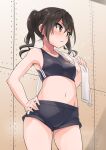  1girl black_hair black_sports_bra breasts brown_eyes covered_nipples cowboy_shot eyebrows_visible_through_hair hair_between_eyes hand_on_hip highres idolmaster idolmaster_cinderella_girls indoors long_hair medium_breasts navel open_mouth short_shorts shorts solo sports_bra standing sunazuka_akira towel twintails yuuichi_(reductionblack) 