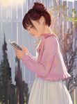  1girl airpods brown_eyes brown_hair cellphone closed_mouth dress fkey from_side hair_bun highres holding holding_phone jacket open_clothes open_jacket original outdoors phone pink_jacket profile signature smartphone solo standing white_dress 