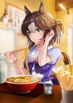  1girl absurdres animal_ears bangs blowing_on_food blurry blurry_background blush breasts breath brown_hair chopsticks clover_hair_ornament commentary_request fine_motion_(umamusume) food green_eyes hair_bun hair_ornament hanamura_pink hand_in_hair hanging_light highres holding holding_chopsticks horse_ears horse_girl horse_tail indoors looking_at_viewer medium_breasts multicolored_hair noodles purple_shirt ramen sailor_collar school_uniform shirt short_sleeves sitting solo table tail tracen_school_uniform tray two-tone_hair umamusume 