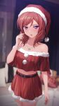  1girl bare_shoulders blurry blurry_background couch cowboy_shot crop_top cushion hand_up hat jewelry love_live! love_live!_school_idol_project medium_hair midriff navel necklace nishikino_maki red_skirt redhead santa_costume santa_hat shamakho skirt solo violet_eyes 