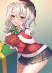  1girl artist_name blue_eyes blush box capelet christmas cowboy_shot eyebrows_visible_through_hair fur-trimmed_capelet fur_trim gift gift_box grey_skirt hair_between_eyes hat kantai_collection kashima_(kancolle) long_sleeves official_alternate_costume open_mouth pleated_skirt red_capelet red_headwear santa_costume santa_hat short_hair signature silica_(silica_silylate) silver_hair skirt solo twintails 