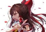  1girl absurdres arm_up ascot bangs bare_shoulders bow brown_eyes brown_hair detached_sleeves eyelashes falling_petals fingernails frilled_hair_tubes frilled_shirt_collar frills from_side hair_bow hair_tubes hakurei_reimu highres light_smile lips long_hair looking_to_the_side mouth_hold nontraditional_miko ofuda petals ponytail red_bow red_vest rose_petals sarashi shiny shiny_hair sidelocks simple_background solo standing touhou vest white_background white_sleeves yamanakaume yellow_ascot 