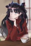  1girl absurdres aiharaart artist_name bangs black_hair black_ribbon blue_eyes blurry blurry_background commentary cup fate/stay_night fate_(series) hair_ribbon hand_up head_rest highres indoors long_hair long_sleeves red_sweater ribbon signature solo steam sweater teacup tohsaka_rin two_side_up upper_body 